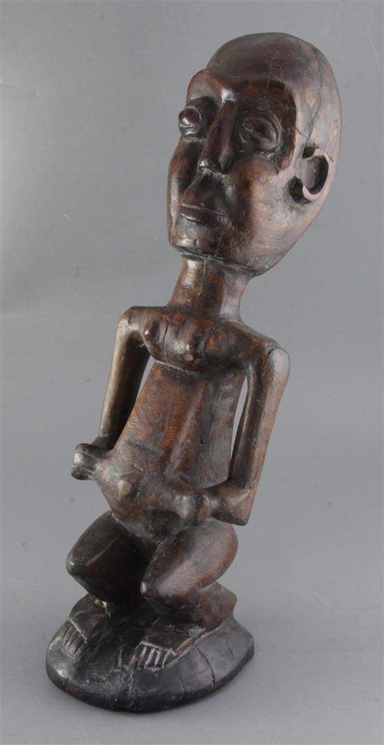 An African hardwood carving of a seated man, 52cm
